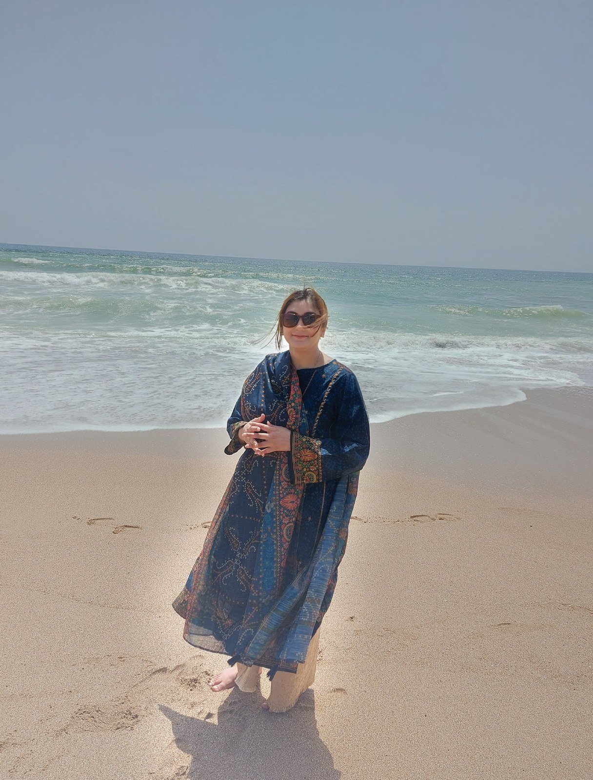 Sana standing at the edge of the surf in Karachi, the original reference photograph